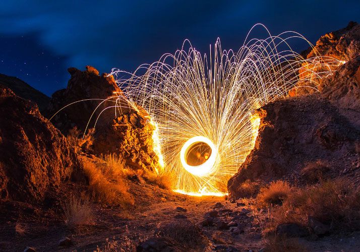 people firing sparklers between rocks